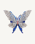 Front view of Tilda Openwork Blue Butterfly Brooch with clear stone lattice wings over blue sculpted layers and a pink centre.