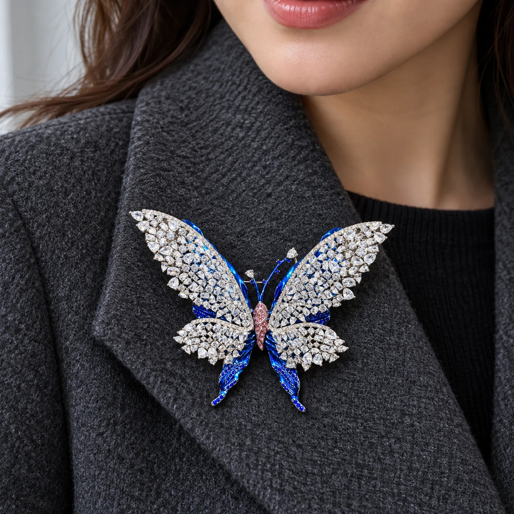 Tilda butterfly brooch pinned inside a broad charcoal wool coat lapel.