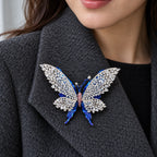 Tilda butterfly brooch pinned inside a broad charcoal wool coat lapel.