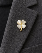 Tova Cat-Eye Clover Magnetic Brooch, Gold & White worn on a charcoal jacket lapel, close view