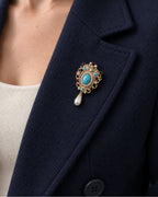 Tove Turquoise-Blue Scroll Drop Brooch — model wearing the brooch on a jacket lapel, close view