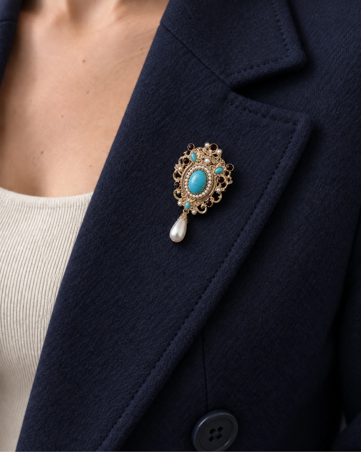 Tove Turquoise-Blue Scroll Drop Brooch — model wearing the brooch on a jacket lapel, close view
