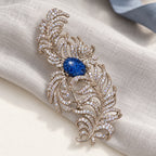 Complete Tuire Blue-Centre Zircon Feather Brooch in an original still life on paper and linen.