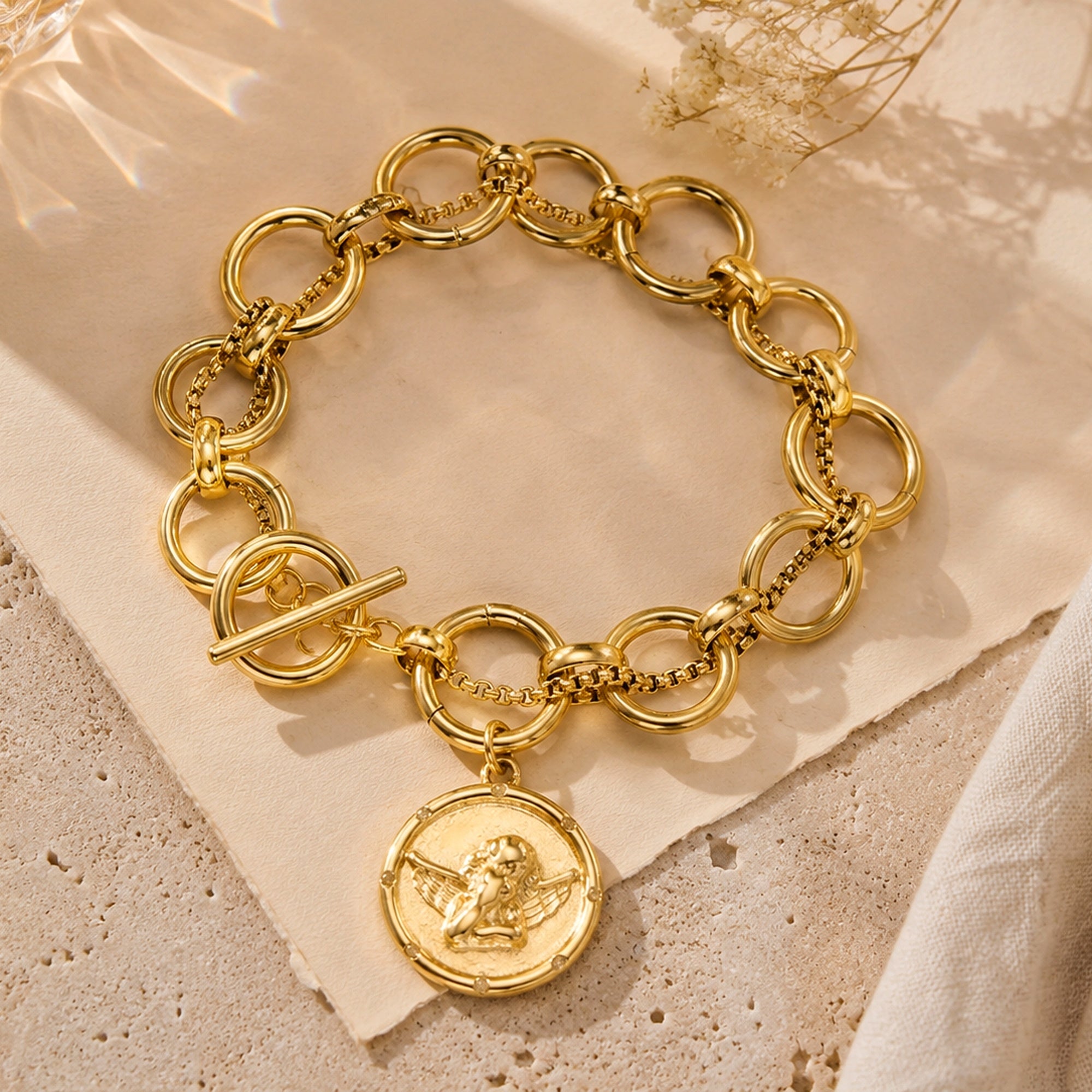 Onni Coin Charm Bracelet showing a polished charm on a warm gold-tone chain