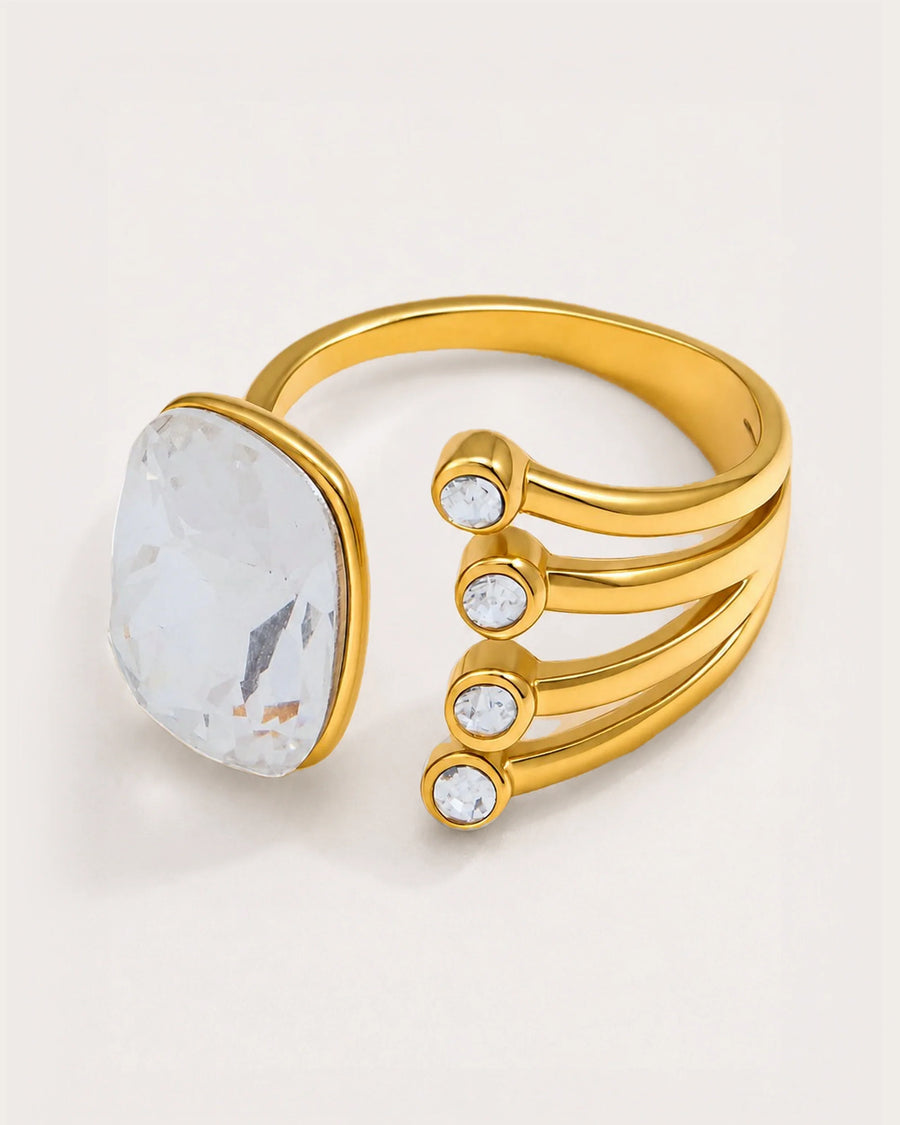 Atrium Adjustable Gold Crystal Ring on a soft warm grey background