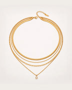 Säde Layered Gold Necklace on a soft warm grey background
