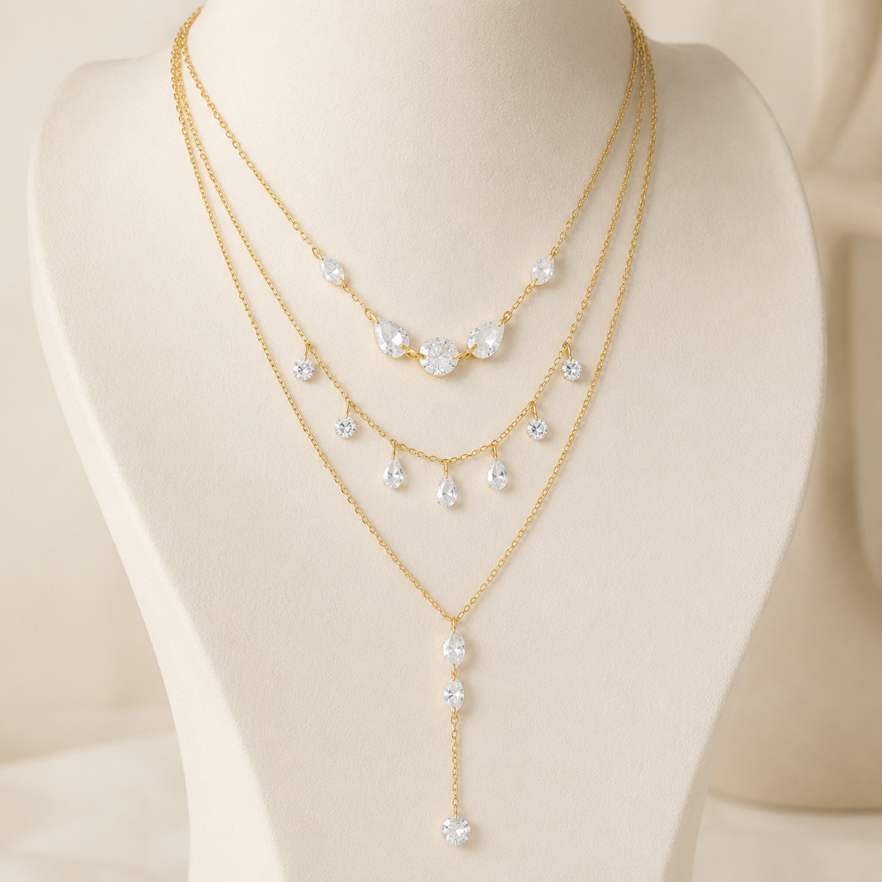 Aurelia Light layered gold crystal necklace displayed on an ivory jewelry bust