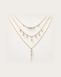 Aurelia Gold Layered Crystal Necklace Set on a soft warm grey background