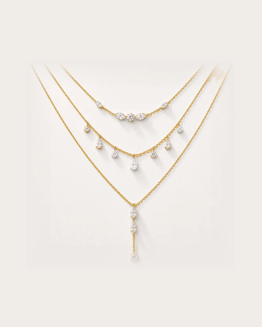 Aurelia Gold Layered Crystal Necklace Set on a soft warm grey background