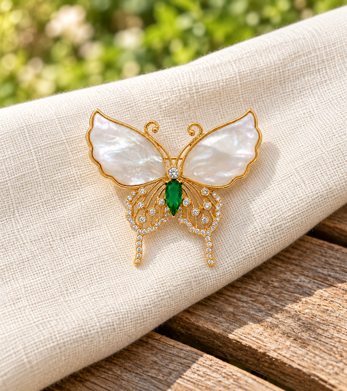 Elina shell butterfly brooch on ivory linen in a garden