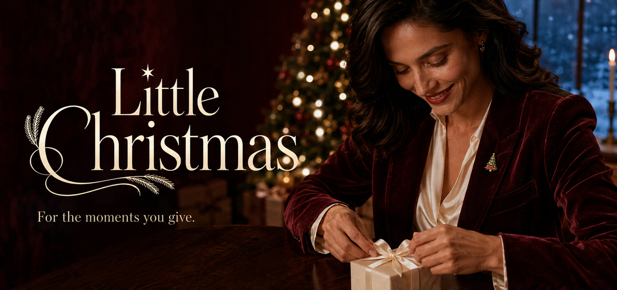 Little Christmas tree brooch on a burgundy lapel while an ivory gift ribbon is tied.