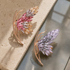 Pink and purple Isla Butterfly Brooch colorways arranged in a tactile still life