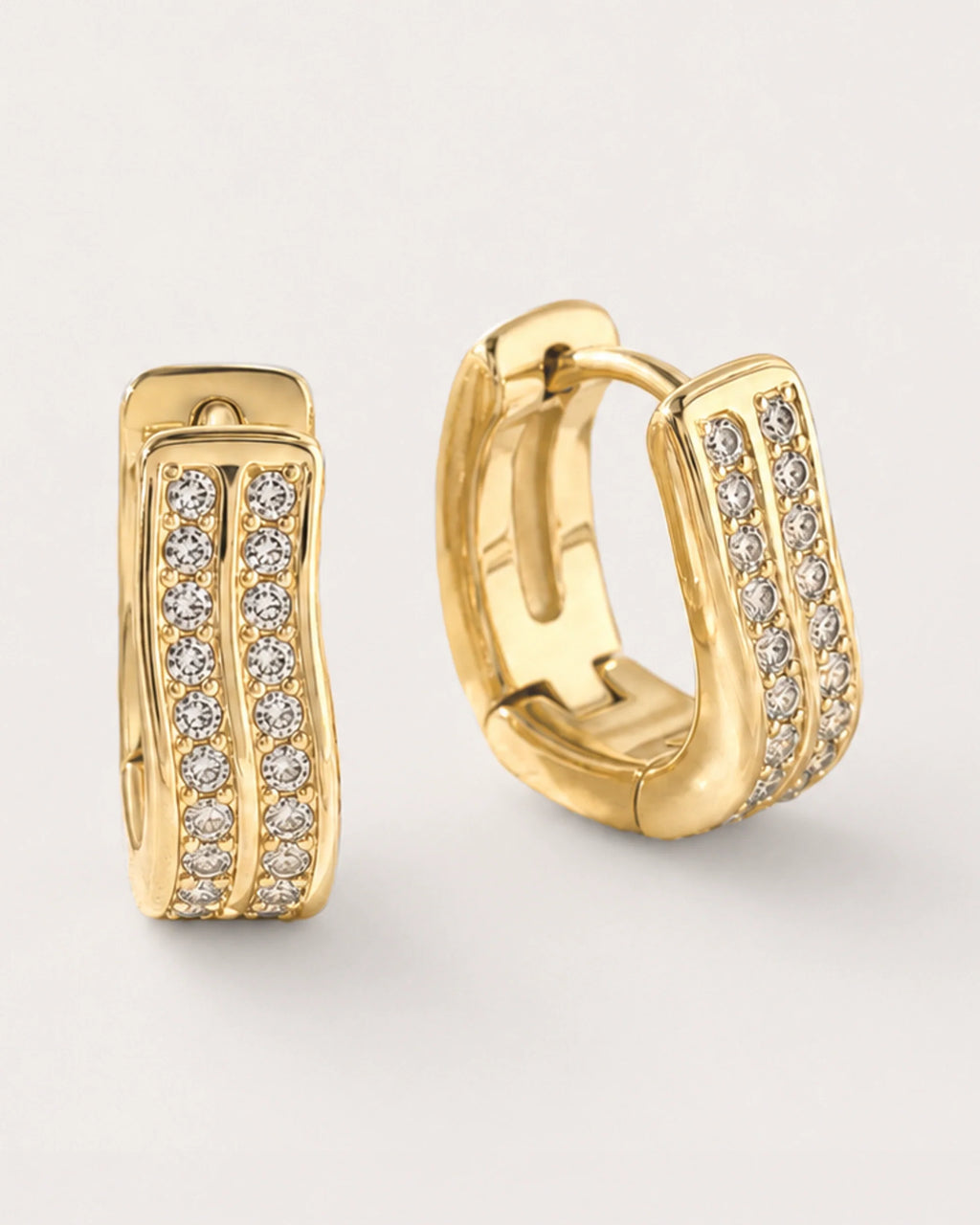 Kide Double-Row Crystal Huggie Earrings on a soft warm grey background