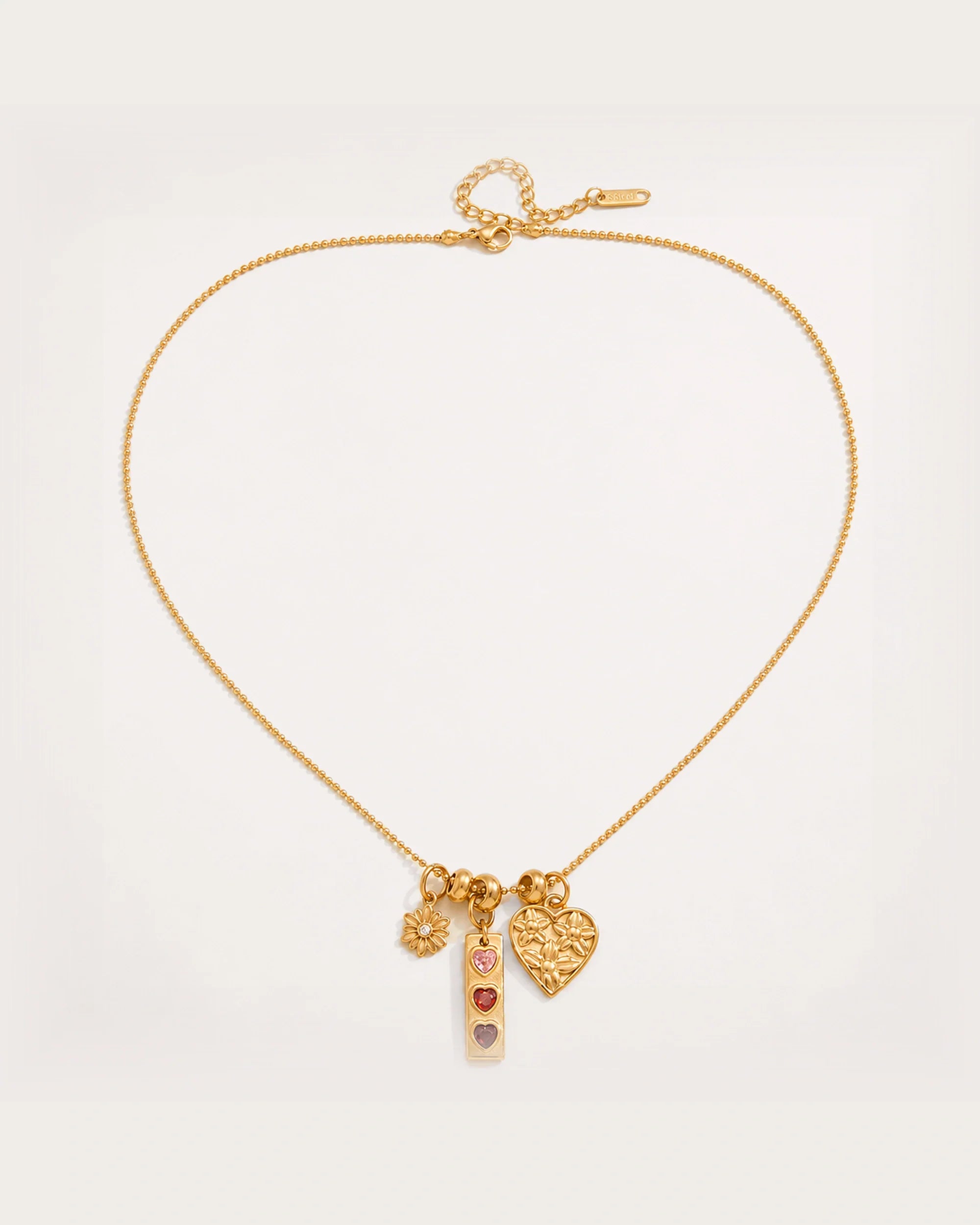 Lempi Daisy Charm Necklace on a soft warm grey background