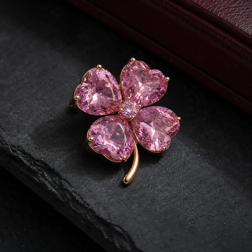 Lykke Pink Clover Brooch on dark slate beside burgundy leather