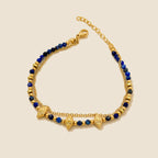 Nila Lapis Charm Bracelet on an exact #EDE3D4 background with soft studio lighting