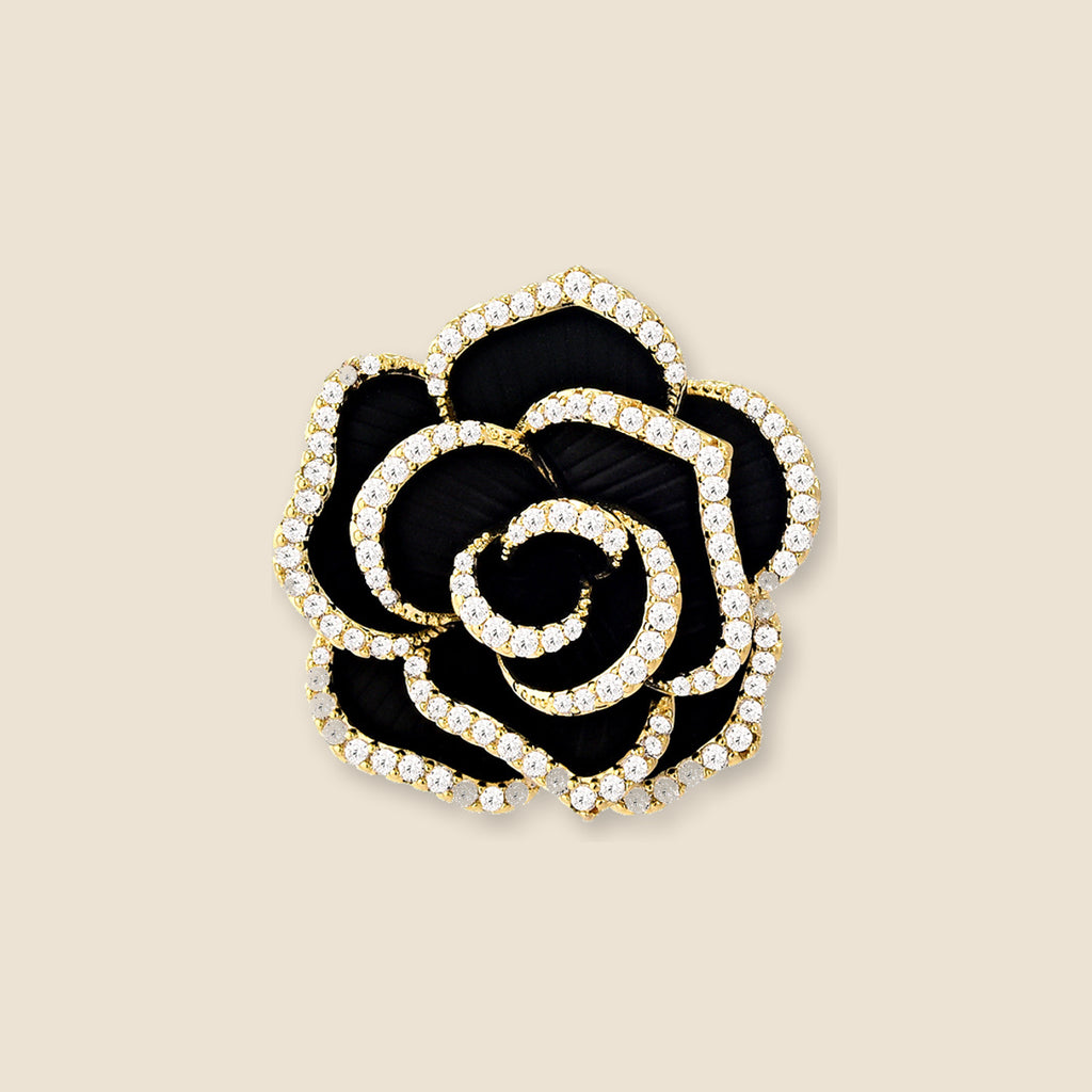 Noir Camellia Brooch in gold, black and clear zircon on an exact #EDE3D4 background