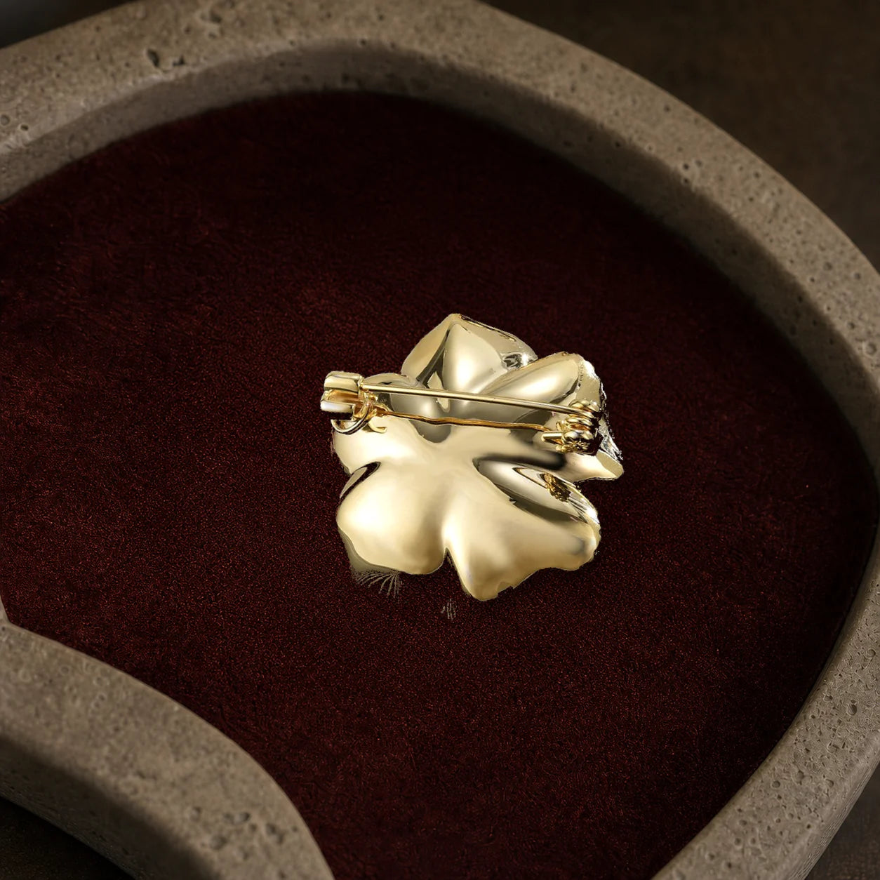 Back view of the Noir Camellia Brooch showing its solid backplate, long pin, hinge and safety clasp