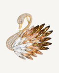 Odette Gold Crystal Swan Brooch on a soft warm grey background