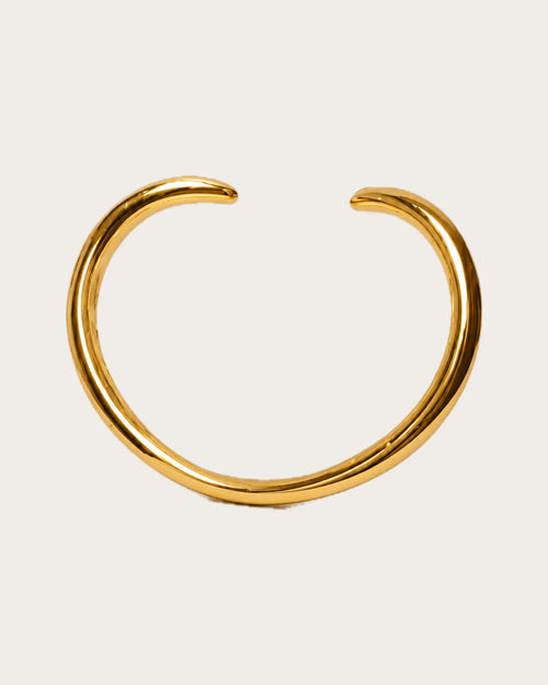 Aalto Gold Heart Cuff Bracelet on a soft warm grey background
