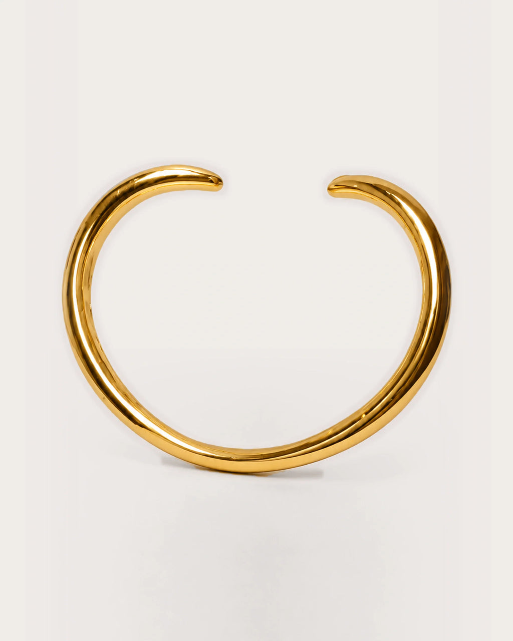 Aalto Gold Heart Cuff Bracelet on a soft warm grey background