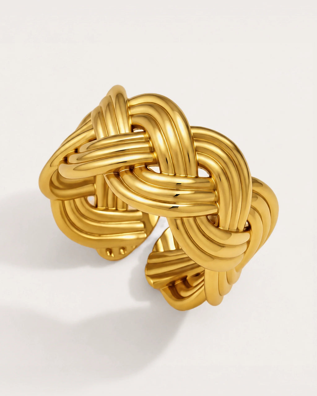 Sola Adjustable Gold Knot Ring on a soft warm grey background
