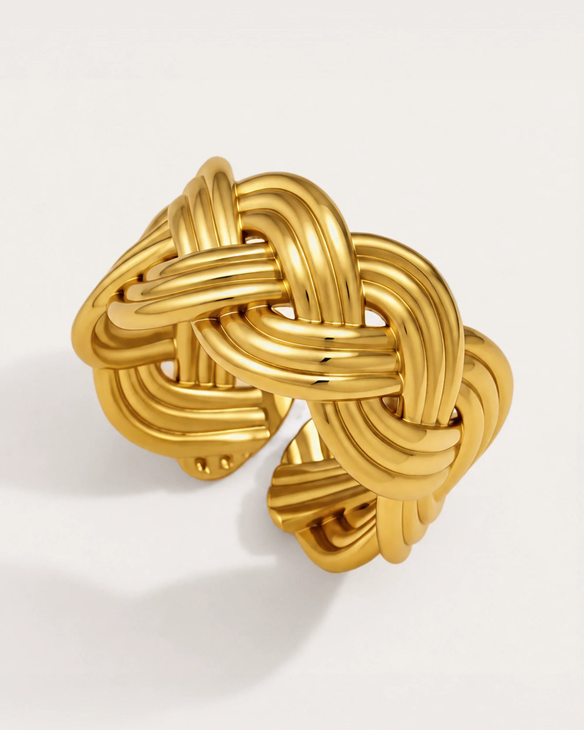 Sola Adjustable Gold Knot Ring on a soft warm grey background