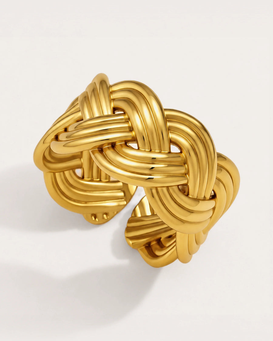 Sola Adjustable Gold Knot Ring on a soft warm grey background