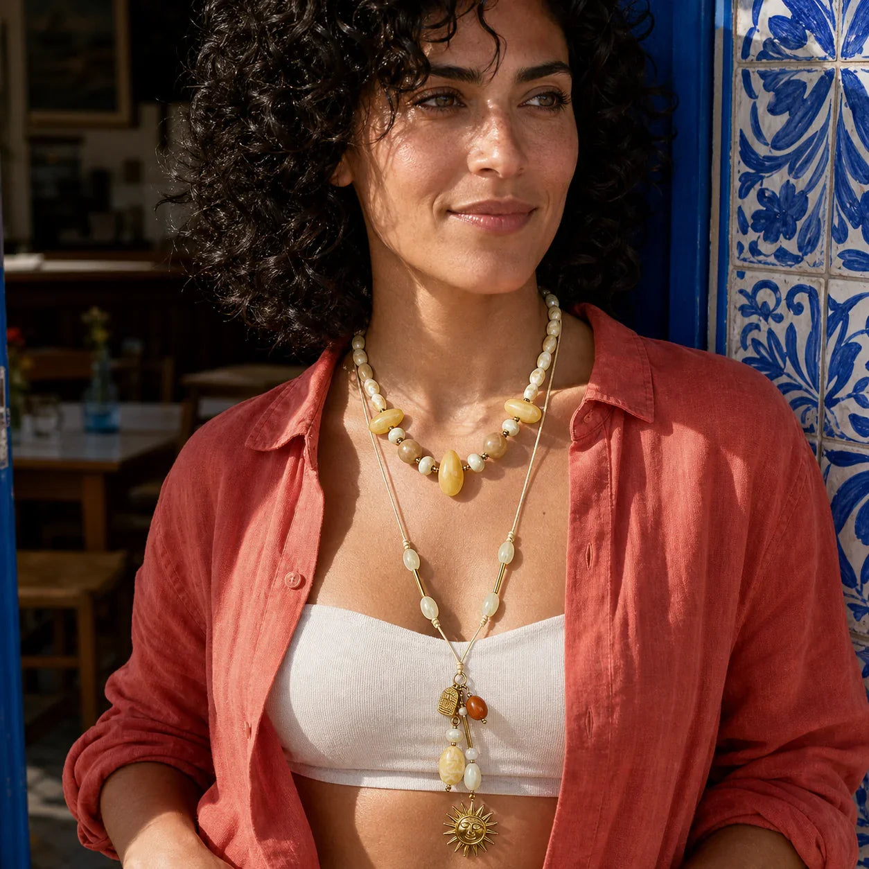 Close view of the Solara Layered Talisman Necklace worn with ivory beads and a long sun pendant