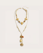 Solara Layered Talisman Necklace on a soft warm grey background