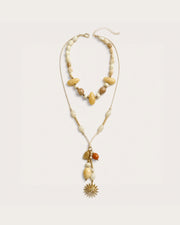Solara Layered Talisman Necklace on a soft warm grey background