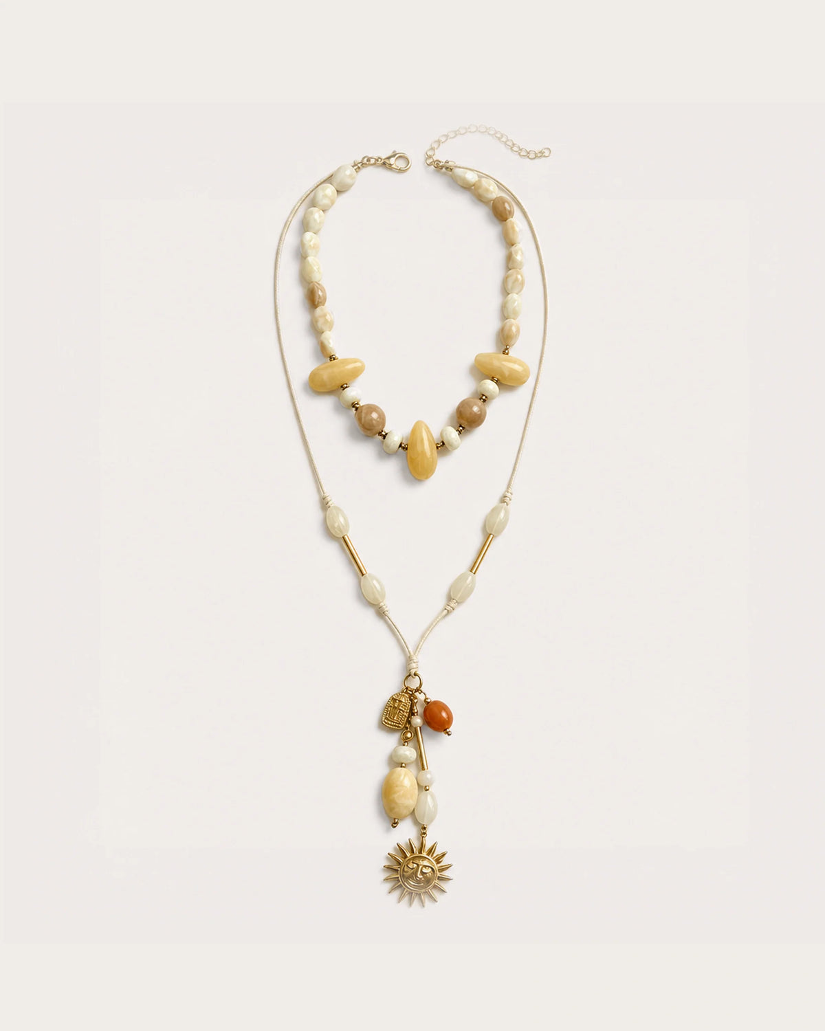 Solara Layered Talisman Necklace on a soft warm grey background