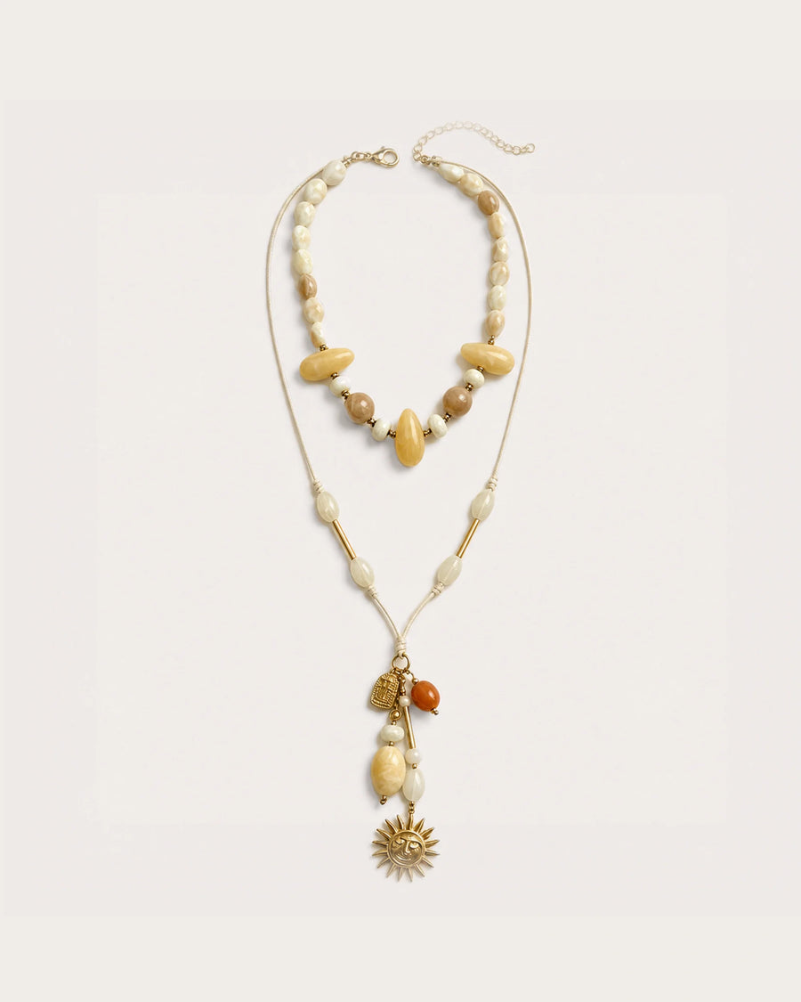 Solara Layered Talisman Necklace on a soft warm grey background