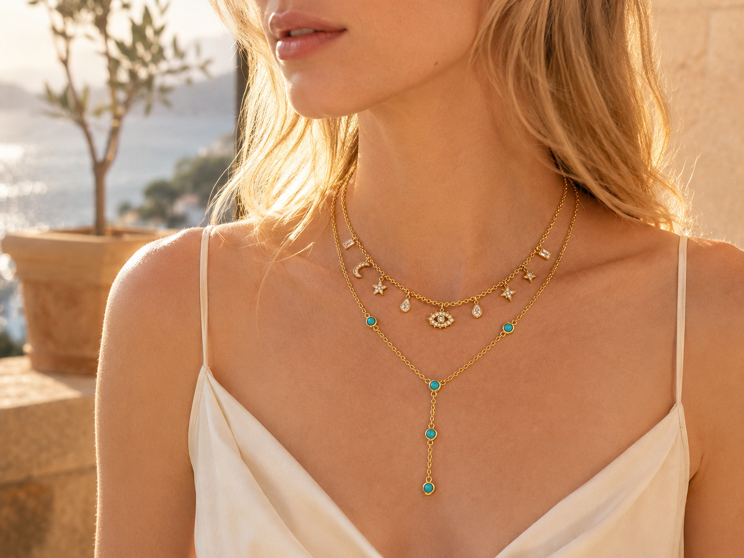 Model wearing warm gold jewelry in summer light