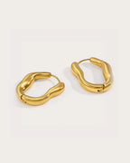 Vela Current Hoop Earrings on a soft warm grey background