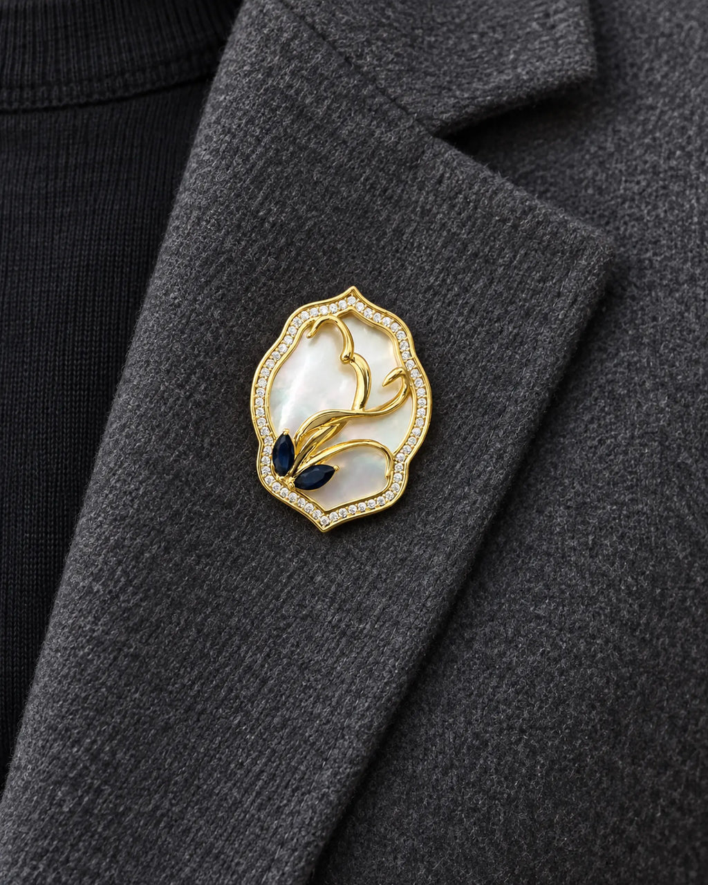 Tuuli Framed Calla Magnetic Brooch, Gold & White worn on a charcoal jacket lapel, close view
