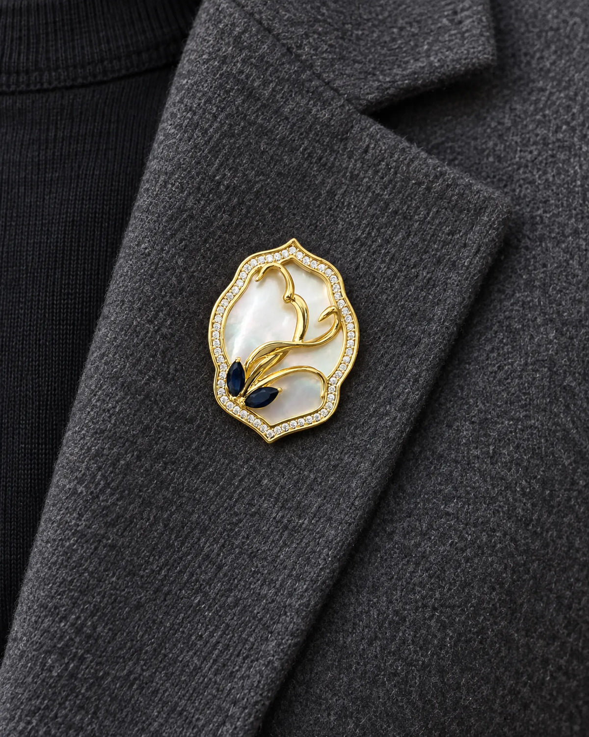 Tuuli Framed Calla Magnetic Brooch, Gold & White worn on a charcoal jacket lapel, close view