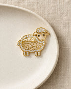 Ulla Openwork Crystal Sheep Brooch on an ivory ceramic dish and linen