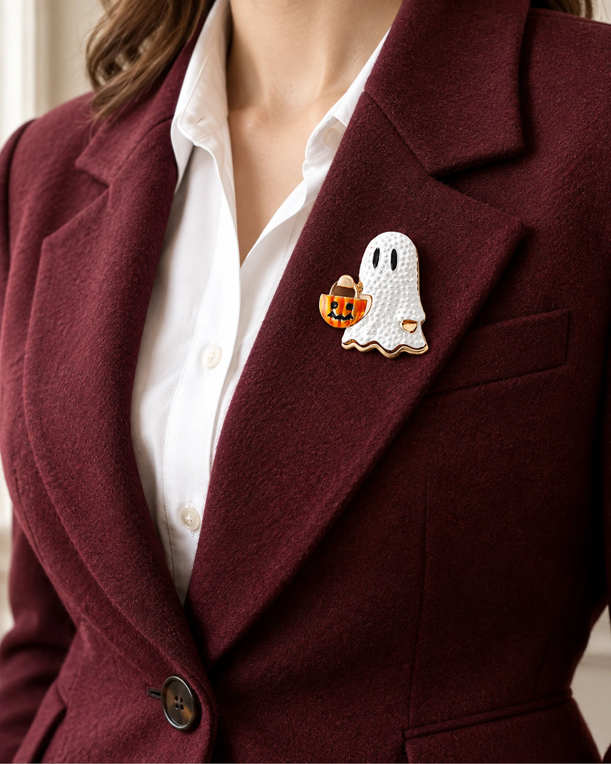 The white ghost and orange bucket sit inside a burgundy lapel over a white shirt.