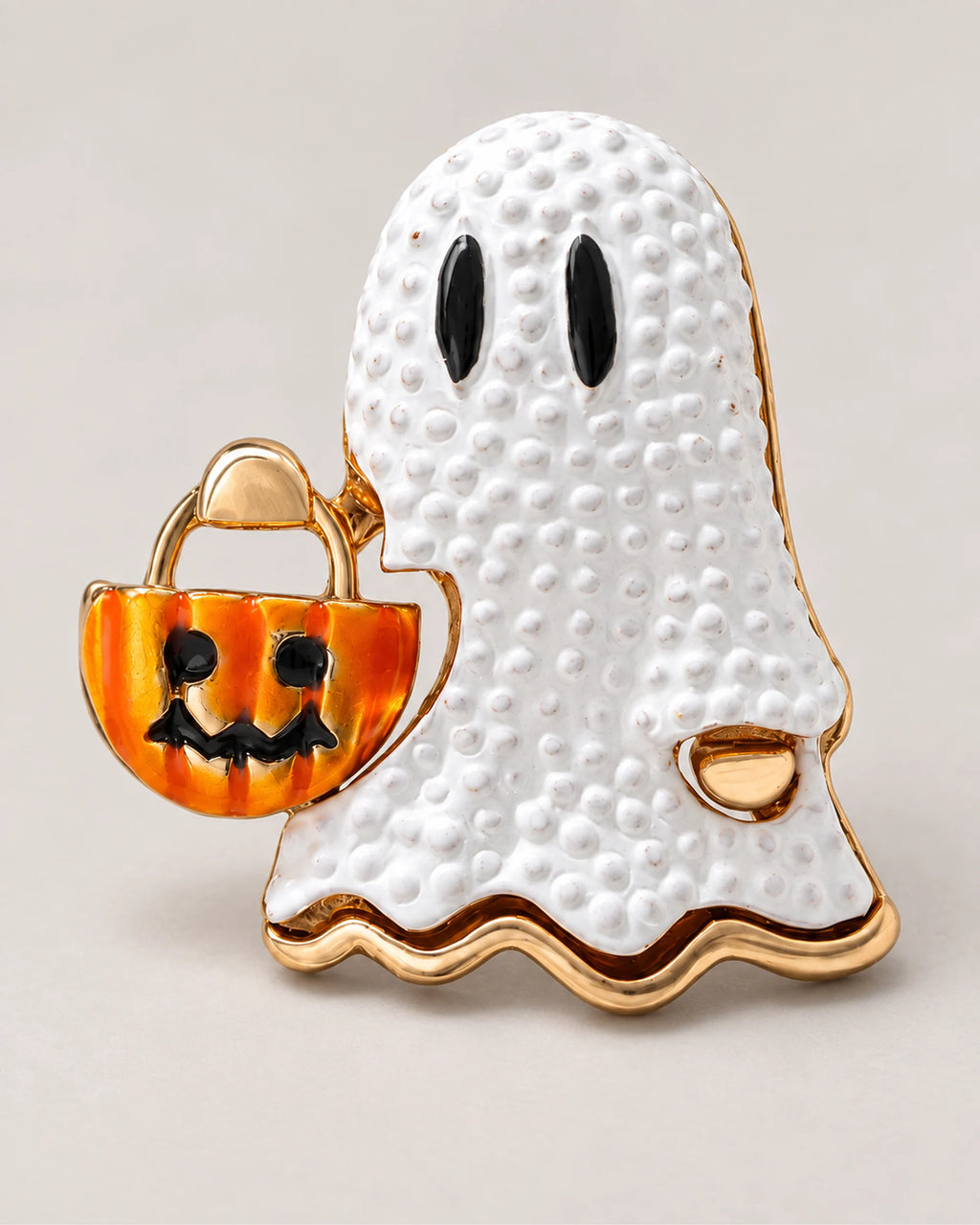 The white textured surface meets black eyes, a gold-tone rim and a small orange bucket.
