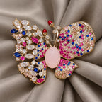 A doubled warm-gray silk scarf fold supports the complete Pink butterfly.