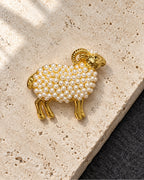 Vilja Imitation Pearl Ram Brooch on pale travertine above charcoal felt