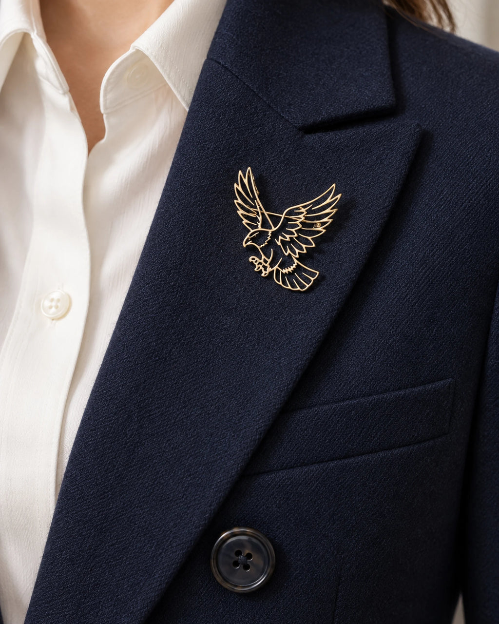 Vinge openwork eagle brooch pinned inside a navy blazer lapel