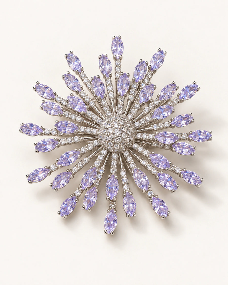 Viola silver-tone lavender zircon starburst brooch on an ivory surface